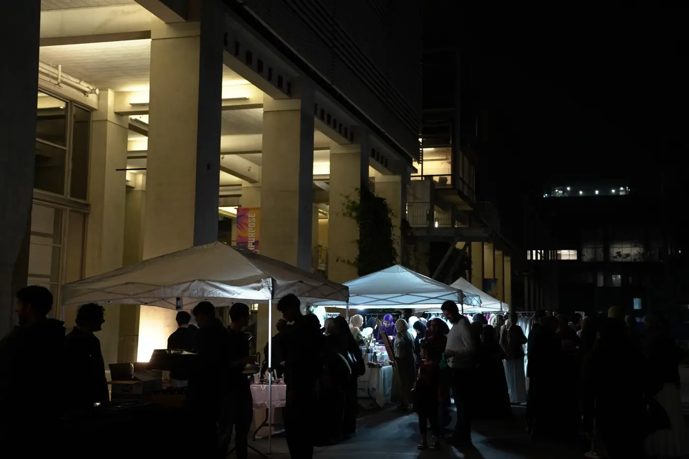 The evening bazaar's canopies glowing outside the venue at night