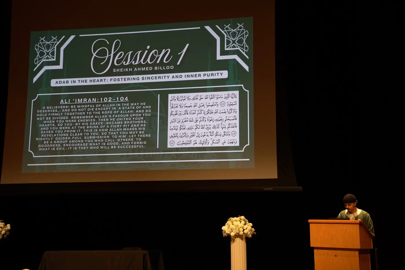 A student reading at the lectern beneath the Session 1 slide