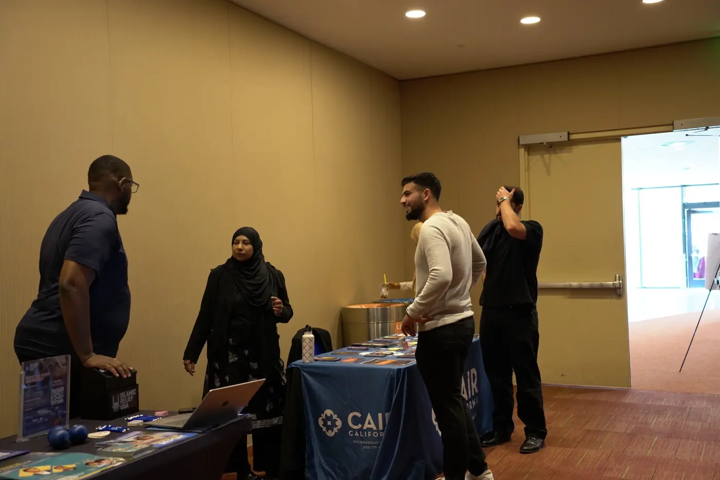 Attendees talking with exhibitors at the CAIR community booth